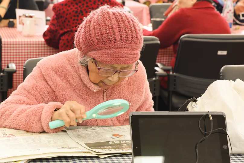 AT magnifying glass old woman