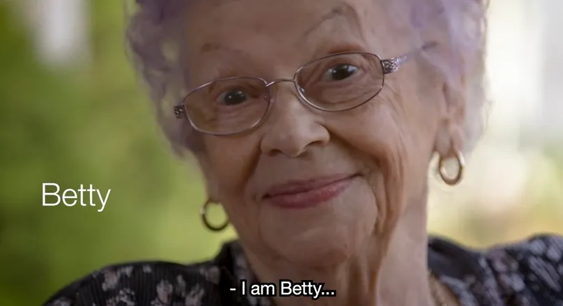 A close-up image of an older woman's smiling face. Text next to her reads her name, 'Betty'. 