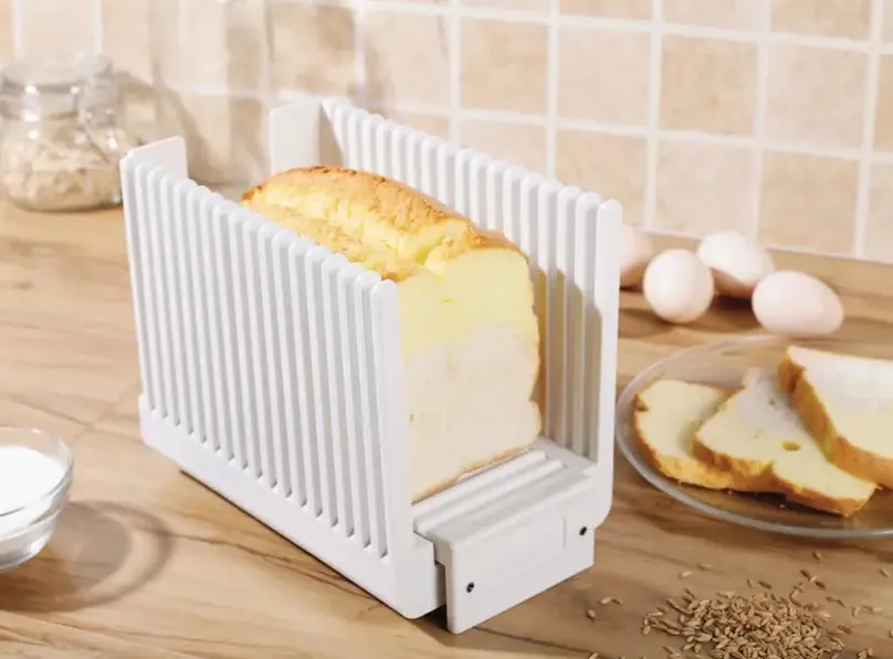 Loaf of bread sitting in a bread slice guide.