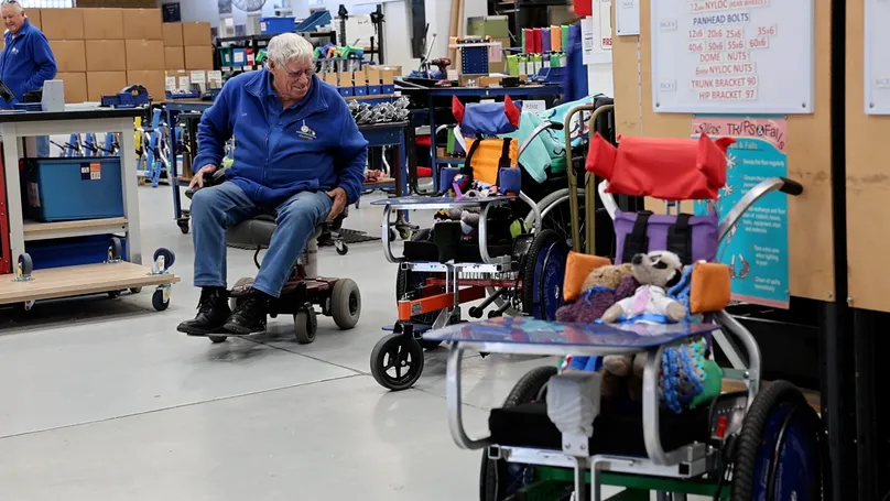 Brother Olly in a wheelchair at his wheelchair factory.