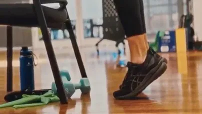 Kamilla Haufort demonstrating a calf raise with both feet, lifting her heels and standing on the balls of her feet.