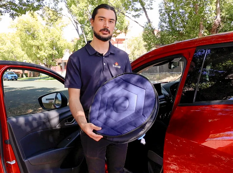 Man holding car cushion.