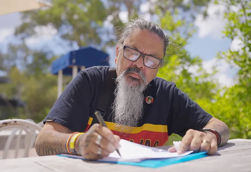 Chris Lee writing with glasses.