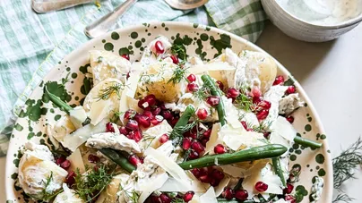 Potato, chicken, and green bean salad with dill yoghurt dressing and red pomegranate seeds.
