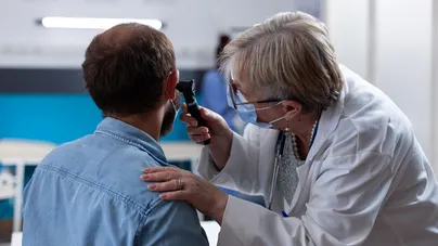 A doctor examining a patient's ear.