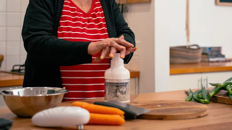 A food wand being used to chop vegetables.