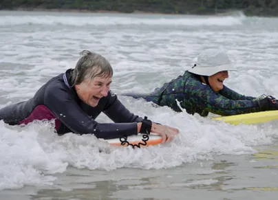 Two older women body surfing.