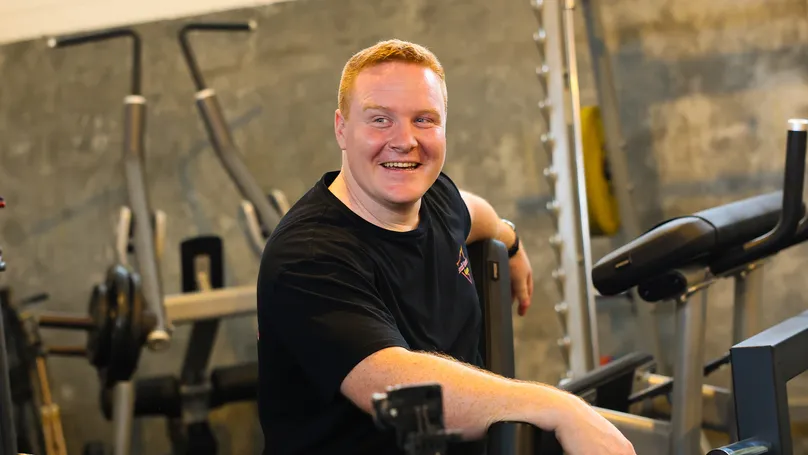 A young man sitting in the gym.