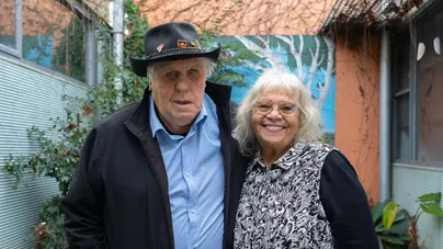 An older First Nations man and woman standing outside