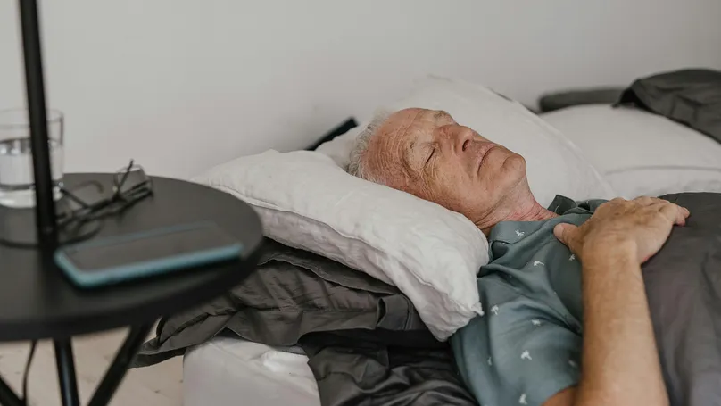 Older man sleeping in bed