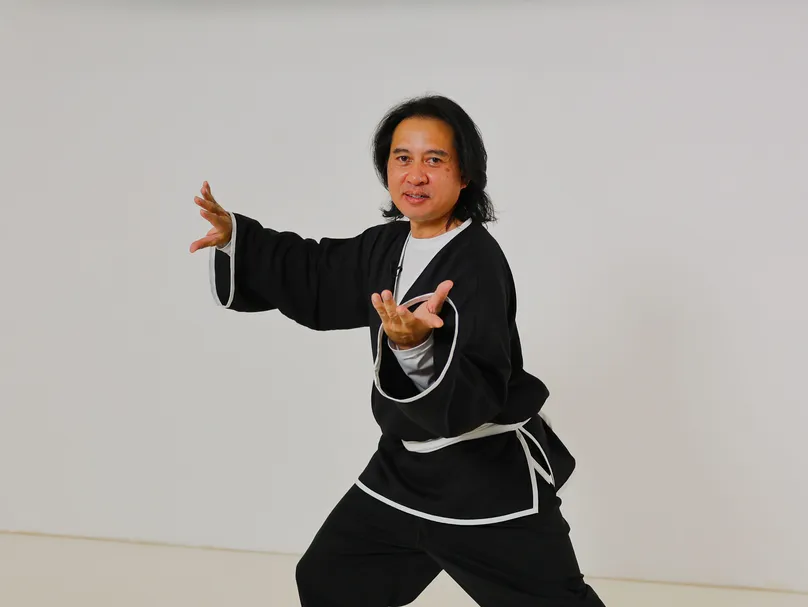 Sam smiling and tai chi pose.