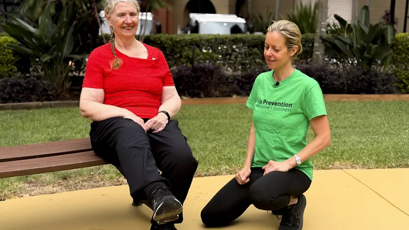 Kamilla Haufort coaching an older woman through a seated leg raise.