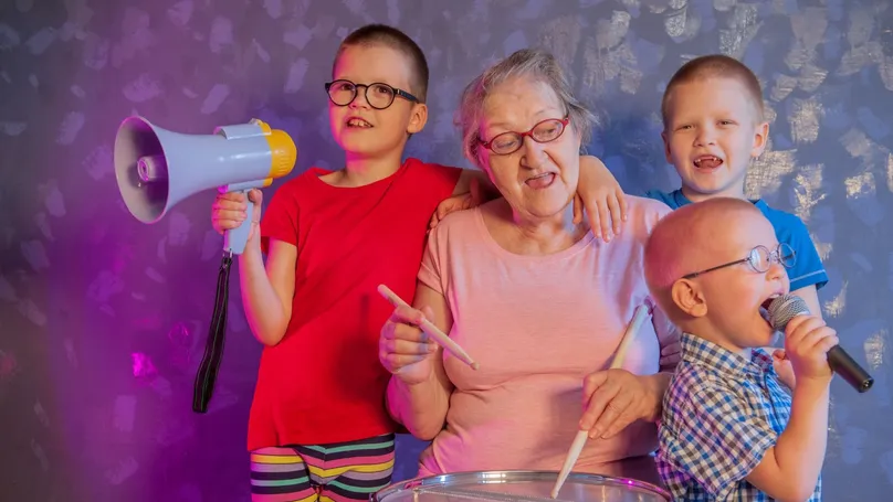 A grandmother drumming while singing with her grandchildren.