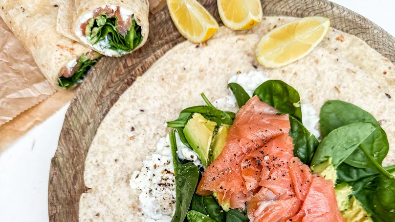A smoked salmon wrap with lemon wedges.