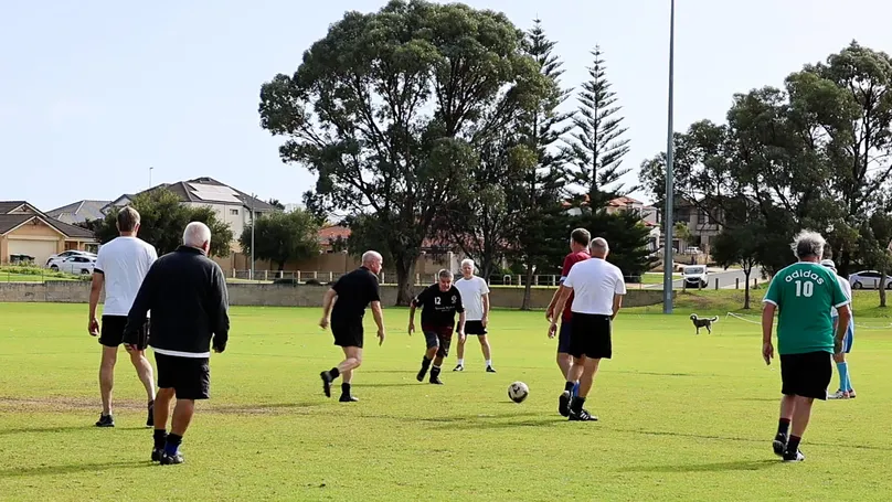 A group of older men playing a game of adapted soccer.