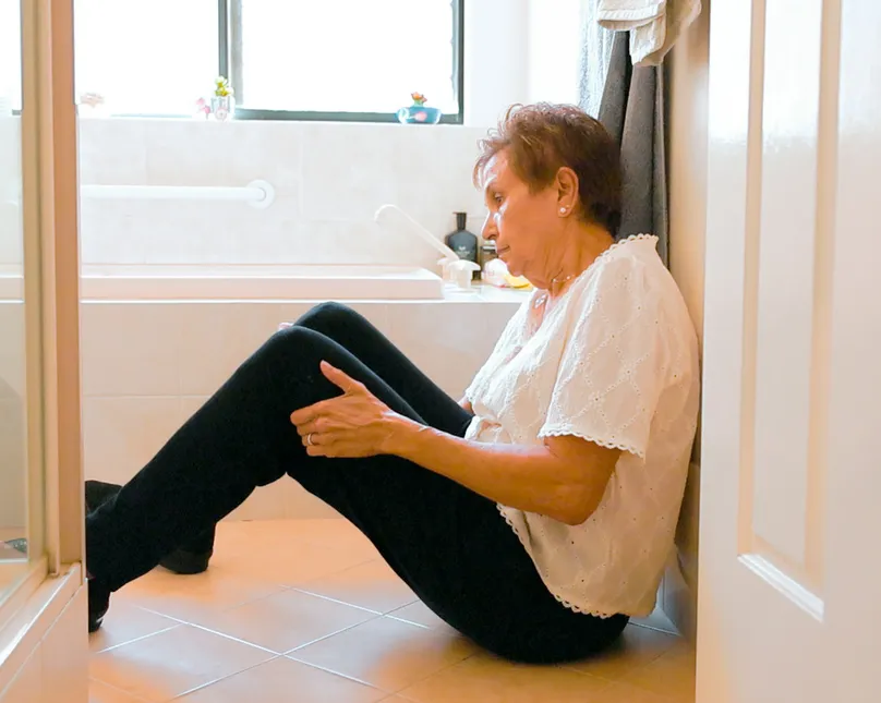 Woman sitting on the floor in the bathroom.